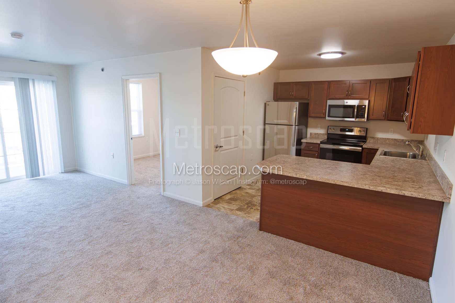 An open-concept living area with a kitchen, a breakfast bar, and access to a balcony.