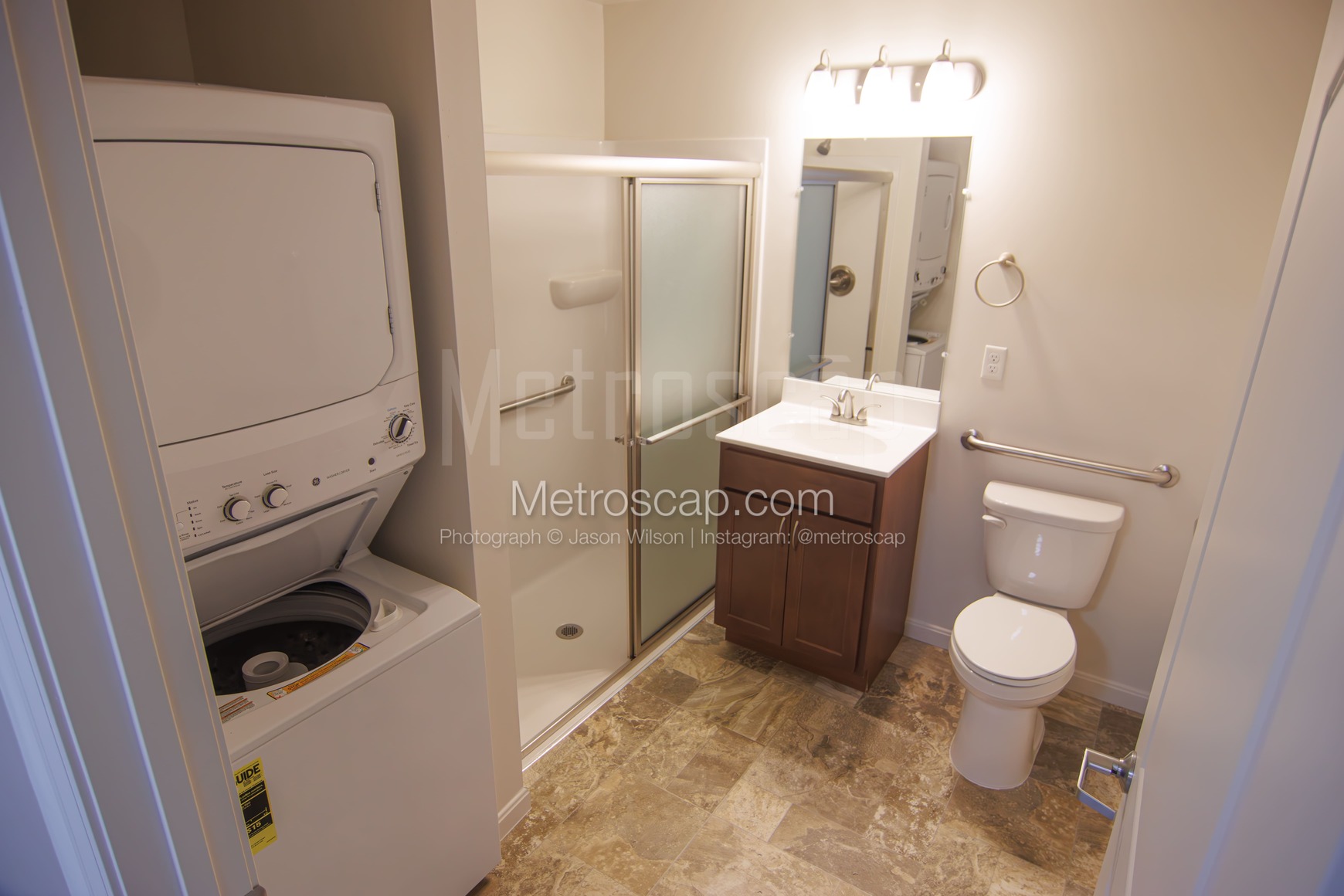 A modern bathroom featuring a stacked washer and dryer